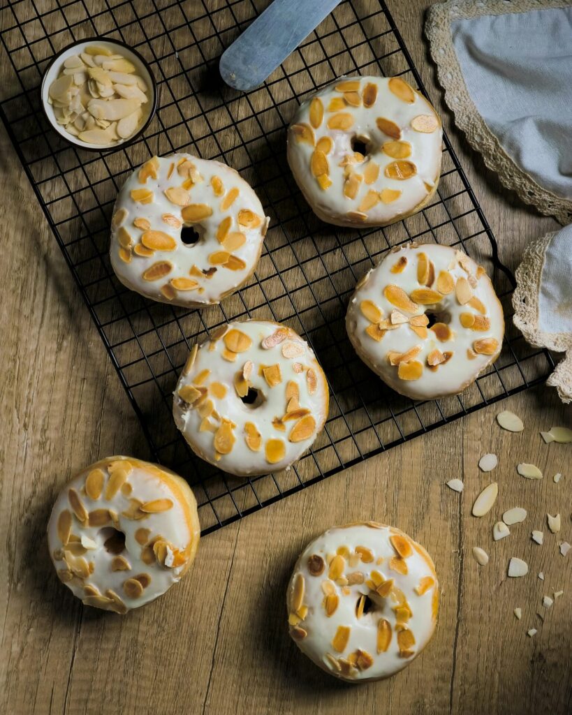 Tasty almond glazed donuts on a cooling rack perfect for food lovers.